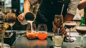 Barkeeper bereitet Cocktails zu mit Zubehör zum Cocktail mixen